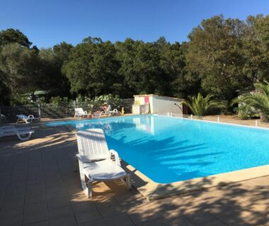 Piscine extérieure avec chaises longues au Camping Pezza Cardo