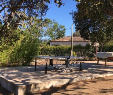 Espace extérieur avec table de ping-pong et cheval en bois au Camping Pezza Cardo