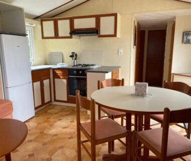 Cuisine et coin repas avec table ronde dans le mobil-home du Camping Port Mer Plage Cancale