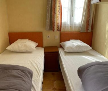 Chambre avec deux lits simples et fenêtre au Camping Port Mer Plage à Cancale