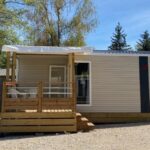 Emplacement ombragé avec mobil-home et terrasse au Camping Porte des Vosges