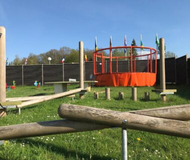 Aire de jeux avec trampoline et parcours en bois au Camping Porte des Vosges