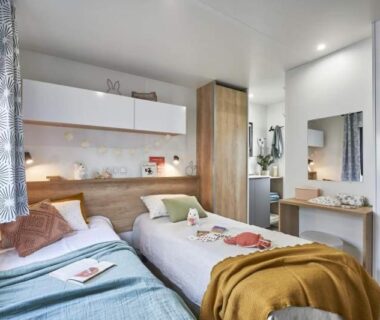 Chambre intérieure avec deux lits et rangement dans le Camping Porto Vecchio