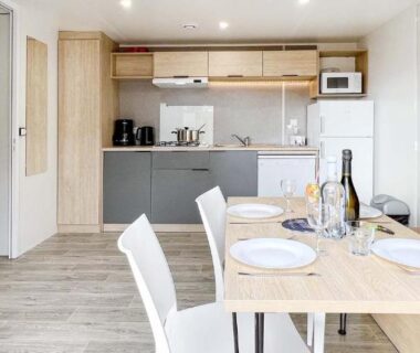 Séjour avec kitchenette et table dressée au Camping Porto Vecchio