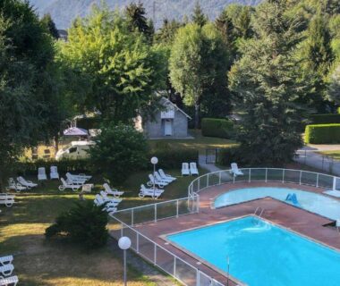 Piscine extérieure avec transats et pelouse du Camping Pradelongue