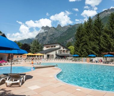 Piscine extérieure avec transats et parasols au Camping RCN Belledonne