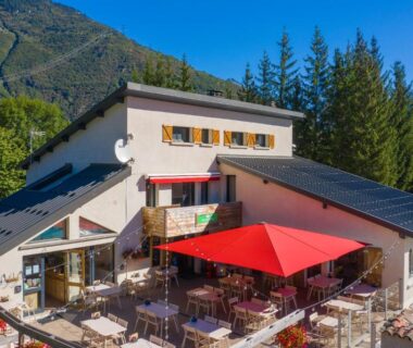 Terrasse extérieure avec parasols rouges au Camping RCN Belledonne