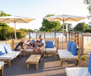 Espace lounge au bord de la piscine du Camping RCN La Ferme du Latois