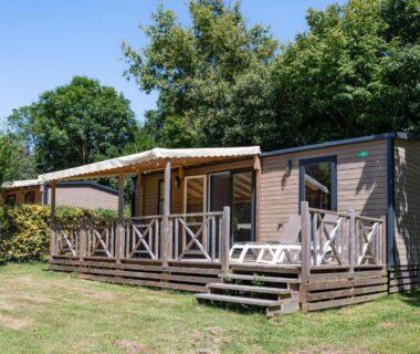Mobil-home avec terrasse en bois et chaises longues au Camping RCN La Ferme du Latois