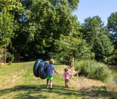 Au bord de l'étang enfants portant bouées au Camping RCN Le Moulin de la Pique