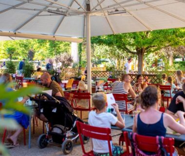 Terrasse ombragée avec tables et parasol au Camping RCN Le Moulin de la Pique