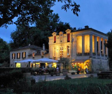 Façade éclairée et terrasse en soirée au Camping RCN Le Moulin de la Pique