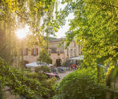 Place ombragée avec terrasses de café au Camping RCN Le Moulin de la Pique