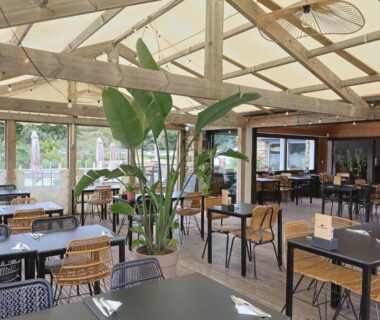 Terrasse couverte avec tables et chaises au Camping RCN Port l'Epine