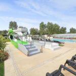 Piscine extérieure avec toboggans et chaises longues au Camping Riva Bella