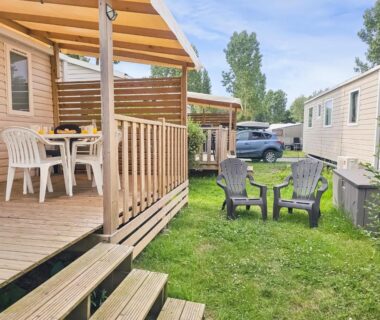 Terrasse en bois et chaises sur pelouse du mobil-home au Camping Riva Bella