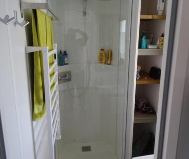 Salle d'eau avec cabine de douche et porte-serviettes dans le mobil-home climatisé et Tv Rivages des Landes