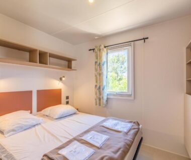 Chambre avec deux lits et serviettes au Camping Rondinara
