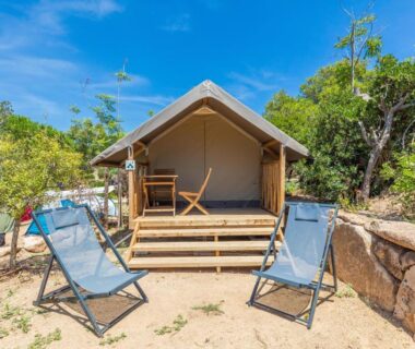 Emplacement sableux avec tente sur terrasse et chaises longues au Camping Rondinara