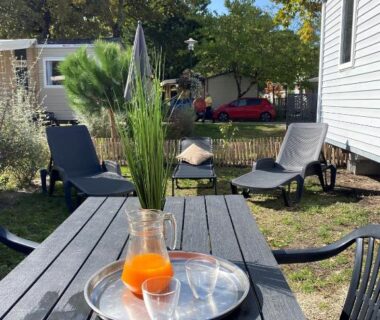 Terrasse extérieure avec carafe et chaises au Camping SIBLU Les Viviers