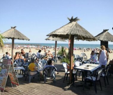 Terrasse en front de mer avec parasols et tables du Camping Sable d'Or 3 chambres
