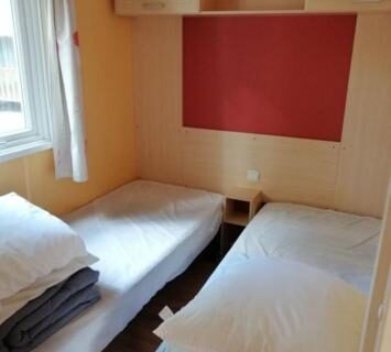 Chambre avec deux lits et rangements dans le Camping Sable d'Or 3 chambres