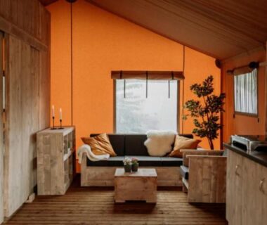 Intérieur du bungalow avec canapé et kitchenette au Camping Saint-Lambert Maeva