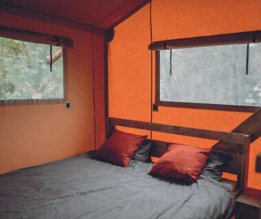 Intérieur de tente avec lit et coussins au camping Saint-Lambert Maeva
