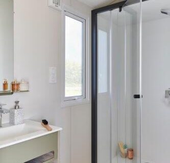 Salle de bains avec cabine de douche et lavabo au Camping Saint Laurent