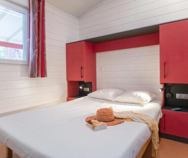 Chambre avec lit double et rangements au Camping San Damiano