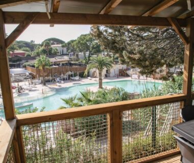 Terrasse en bois sur piscine et palmiers au Camping Site de Gorge Vent