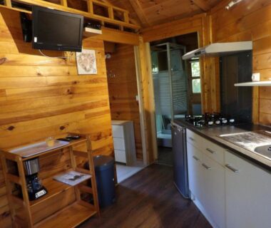 Intérieur avec kitchenette et télévision dans le chalet du Camping Smile & Braudieres