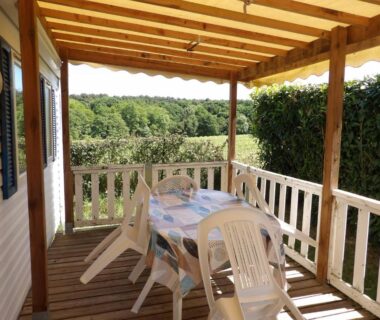 Terrasse couverte avec table et chaises au Camping Smile & Braudieres