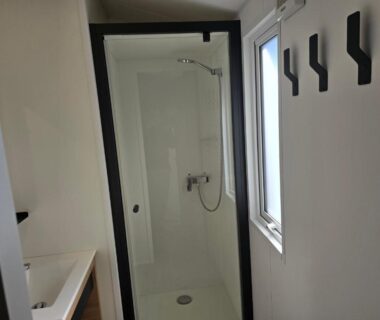 Salle de bains avec cabine de douche et vasque dans le mobil-home du Camping Sol à Gogo