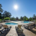 Piscine entourée de transats et solarium au Camping Sole Di Sari
