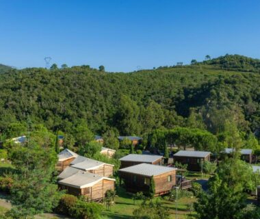 Hameau de chalets en bois au milieu des collines dans le Camping Sole Di Sari