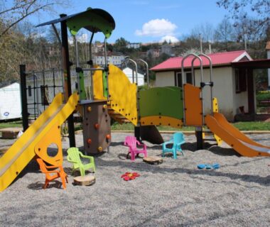 Aire de jeux avec toboggans et chaises colorées au Camping Sud AVEYRON dans le Rougier