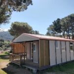 Emplacement herbeux avec mobil-home et terrasse dans pinède au Camping TIKITI