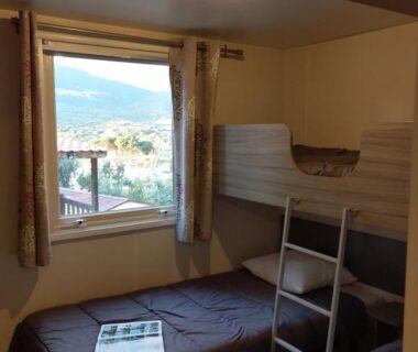 Chambre avec lits superposés et fenêtre avec vue sur la montagne au Camping TIKITI