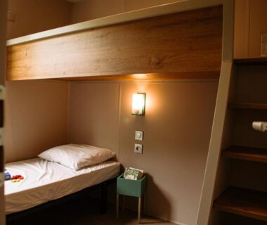 Chambre avec lits superposés et table de chevet au Camping Taxo Les Pins