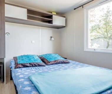 Chambre avec lit double et fenêtre dans le mobil home du Camping Taxo Les Pins Maeva