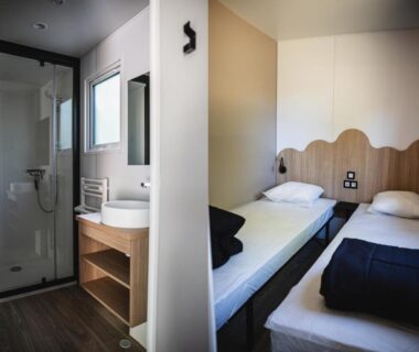 Chambre avec deux lits et salle d'eau au Camping Terre d'Armor