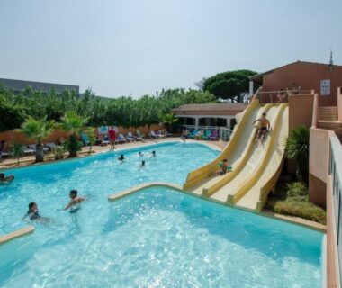 Piscine extérieure avec toboggans et transats au Camping Tikayan Clau Mar Jo Maeva
