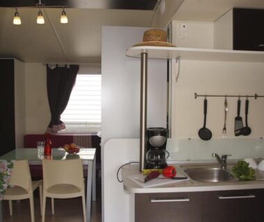 Intérieur kitchenette équipée avec table et chaises au Camping Tikayan Clau Mar Jo Maeva