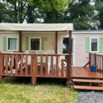 Terrasse en bois avec mobil-home et chaises au camping Tohapi Coeur de Vendée