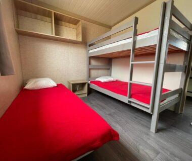 Chambre avec lits superposés et lit simple dans l'hébergement Camping Trinité