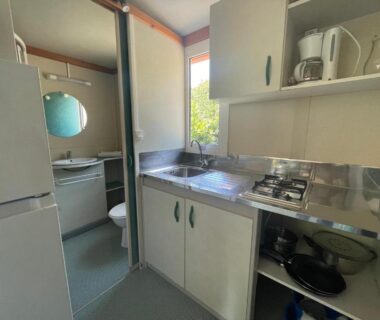 Cuisine équipée avec évier plaque et réfrigérateur dans le mobil-home du Camping Trinité