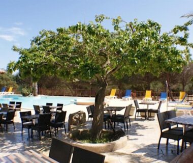 Terrasse extérieure avec tables et piscine au Camping Trinité