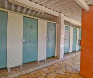 Vestiaires alignés avec portes bleues au Camping U Pirellu