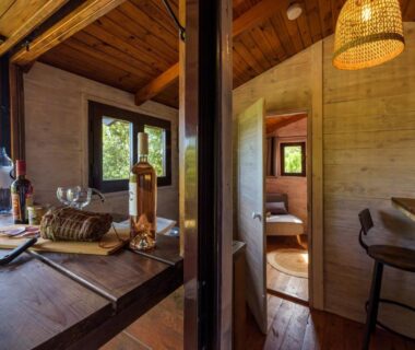 Coin repas en bois avec table dressée et chambre visible au Camping U Pirellu